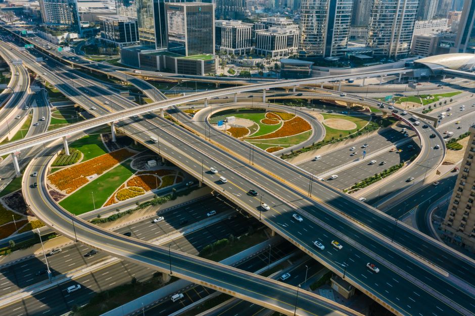 Aerial view of a clean, modern city street splitting into two distinct paths, symbolizing the strategic choice between tra...