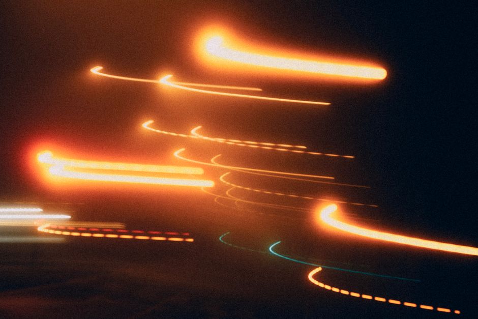 A dark, abstract image featuring a central glowing core with vibrant trails of light radiating outwards, representing a source of information.