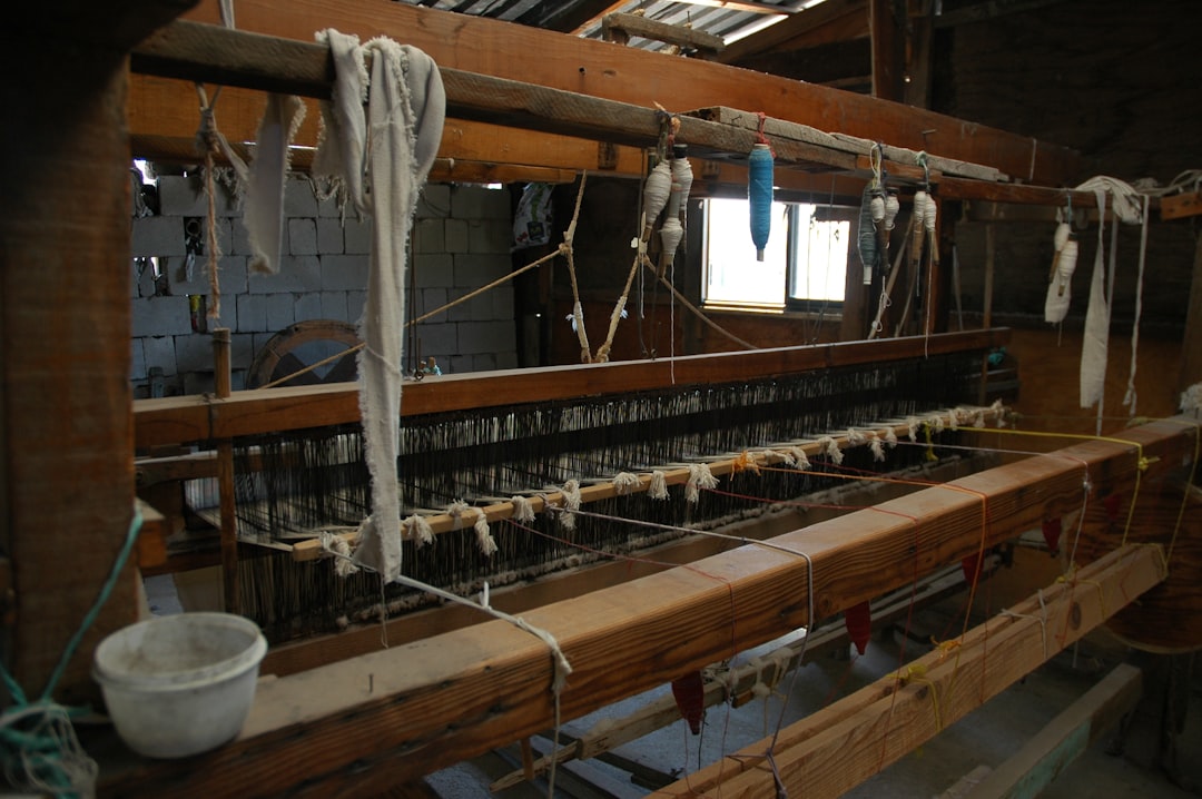A detailed close-up of colorful threads being woven together on a modern loom, illustrating many small elements creating a larger, cohesive whole.