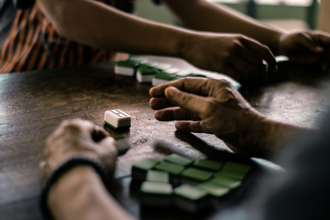 Close-up of hands methodically arranging clean, white geometric blocks on a minimalist table, representing the structured process of building a new brand identity from the ground up.