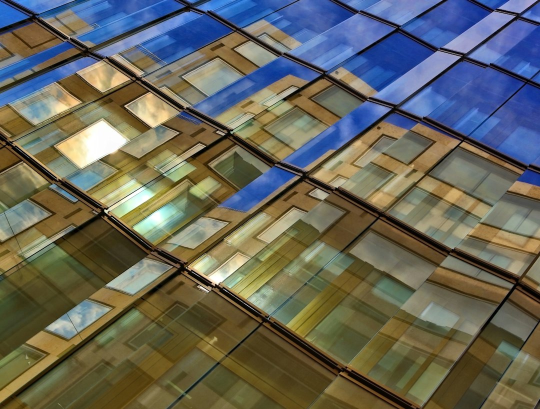 An abstract, brightly lit photograph of overlapping geometric glass panes, symbolizing the new, complex layers of AI in the agentic web.