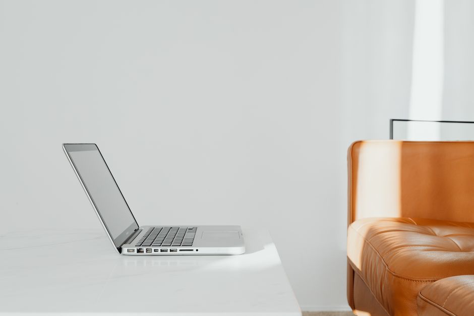 A bright, modern, and minimalist office desk with only a single laptop, symbolizing the efficiency of a unified content pipeline.
