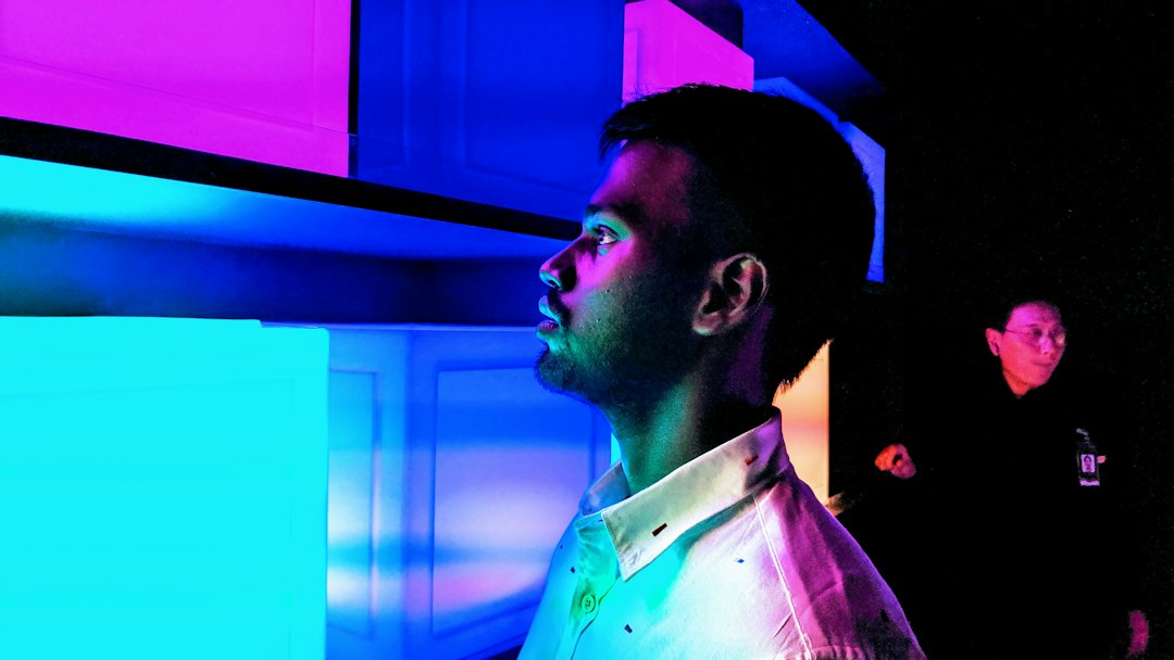A professional in a modern, dark room interacting with a glowing, holographic 3D model of a complex building, symbolizing the future of strategic planning.